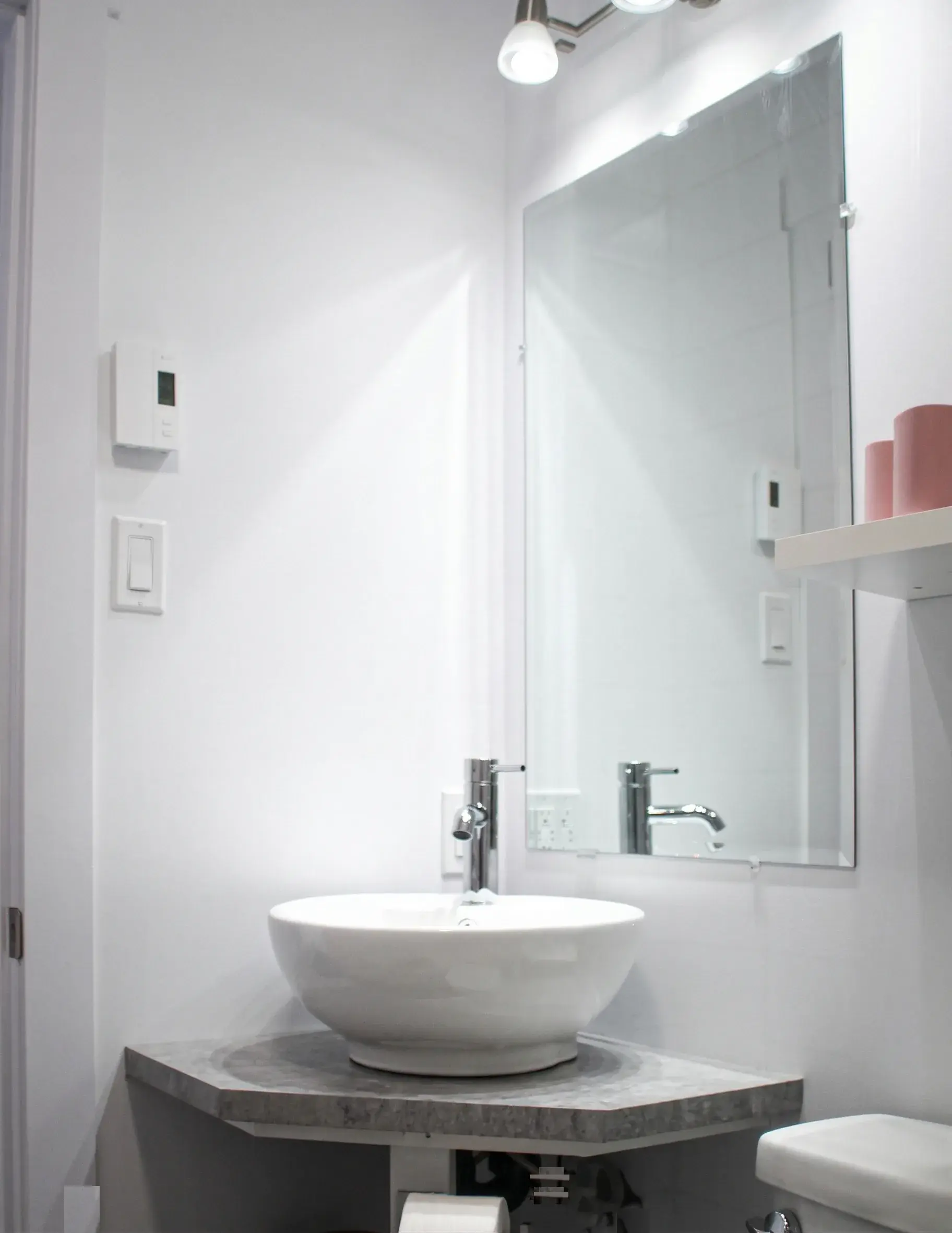 Salle de bain avec vasque ronde sur comptoir gris et grand miroir