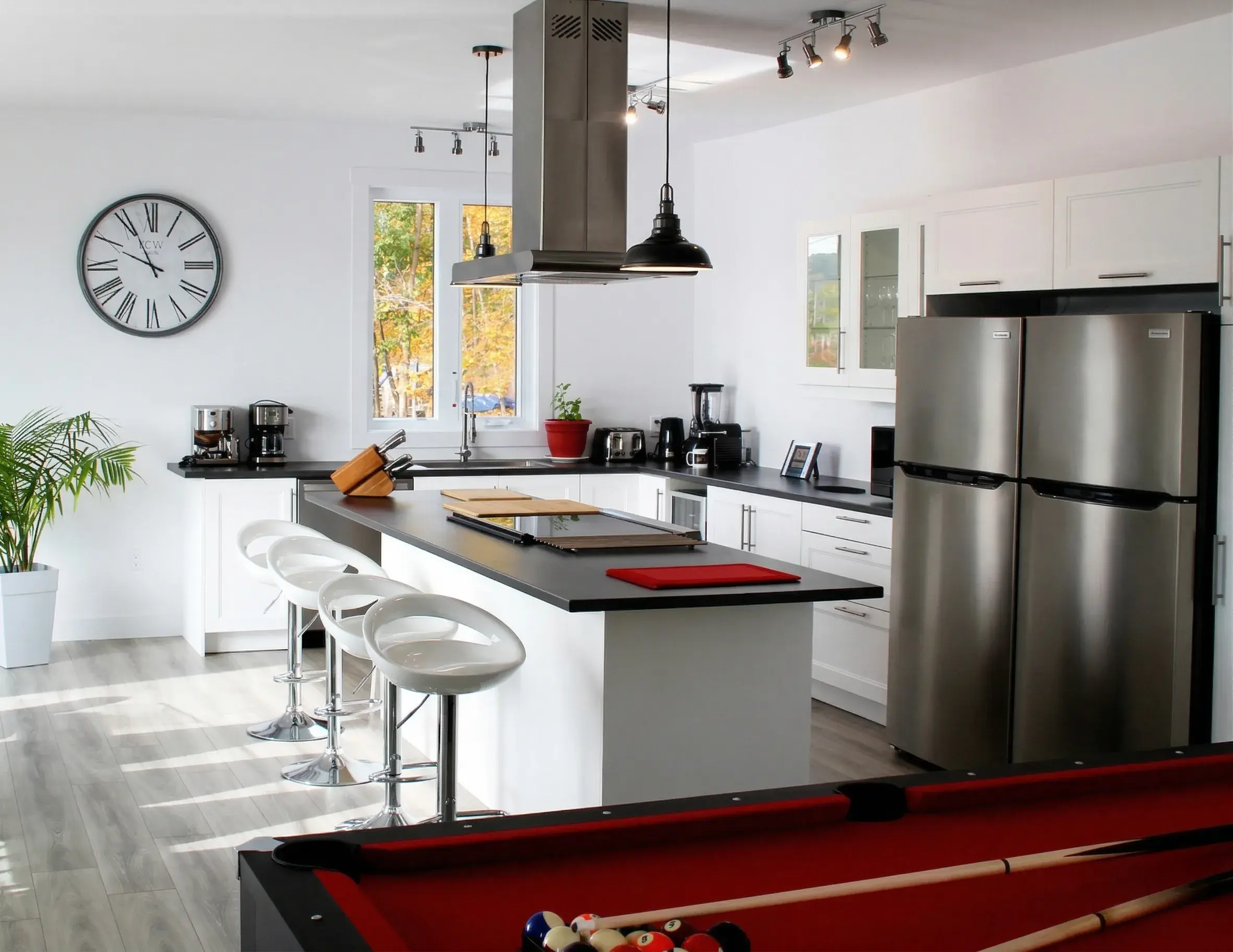 Cuisine ouverte sur l'aire de vie avec table de billard au premier plan