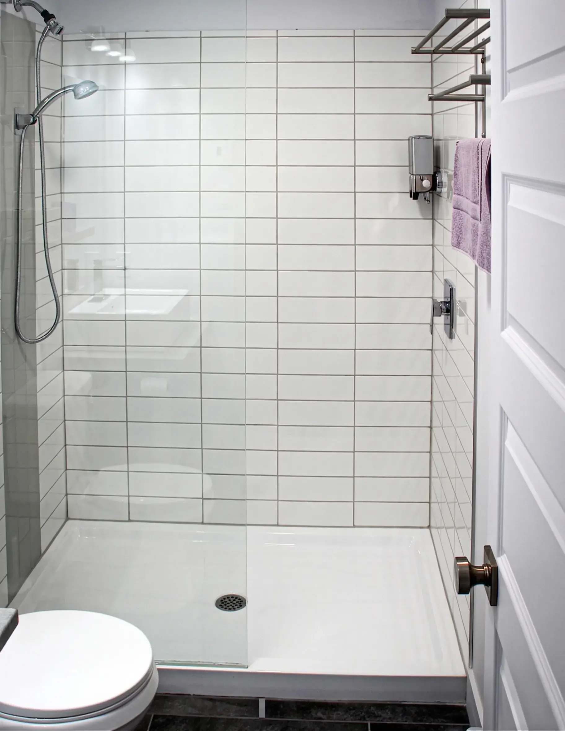 Salle de bain avec douche italienne carrelée de blanc et toilette