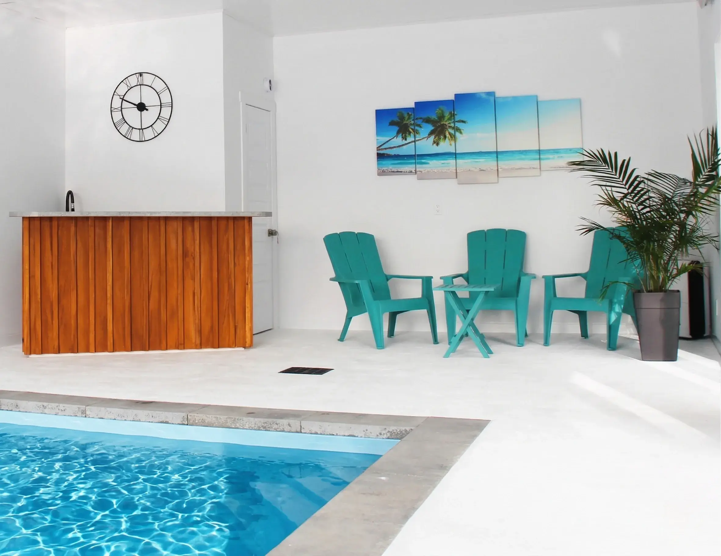 Piscine intérieure chauffée avec coin bar et fauteuils turquoise