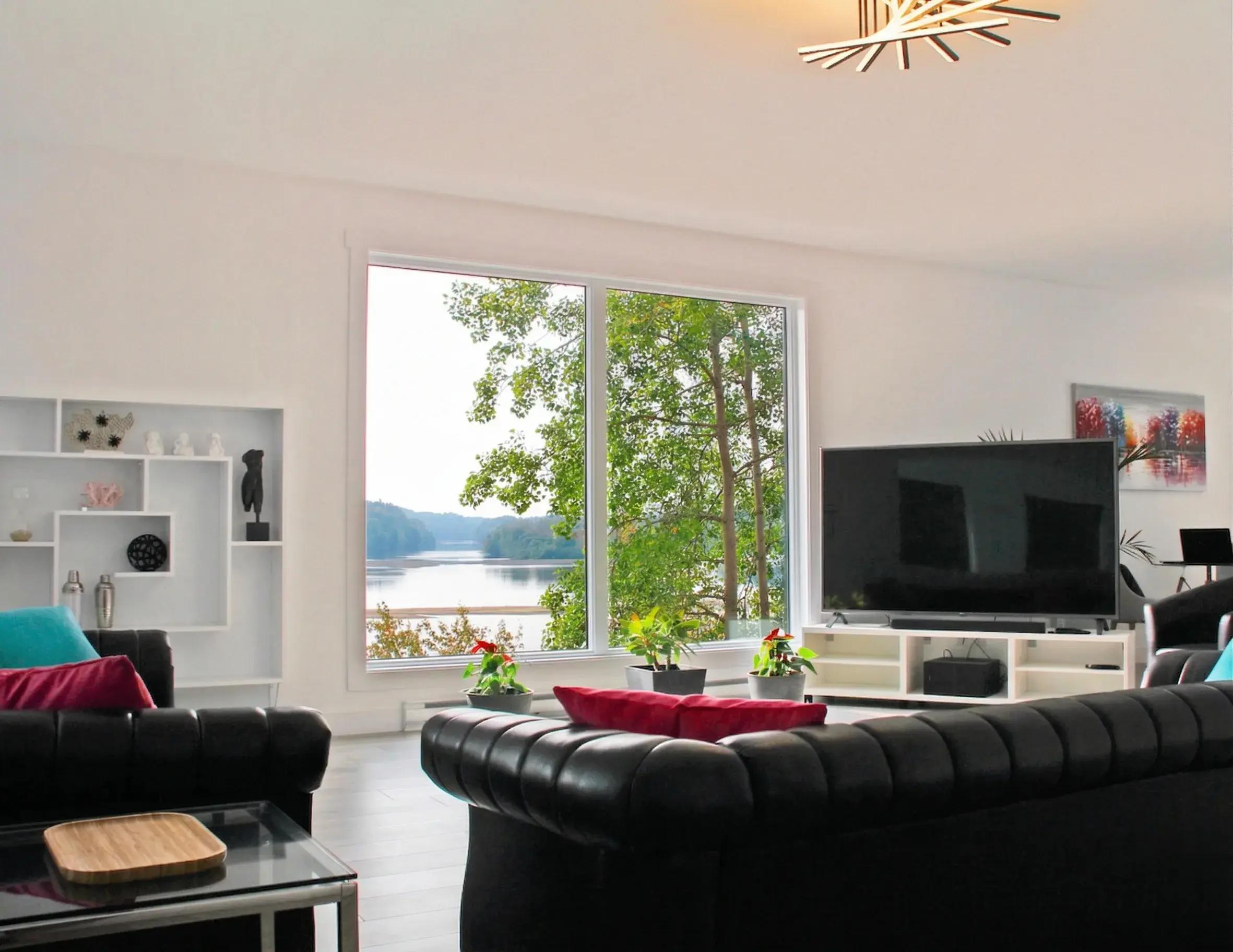 Salon en cuir noir avec grande baie vitrée sur la rivière